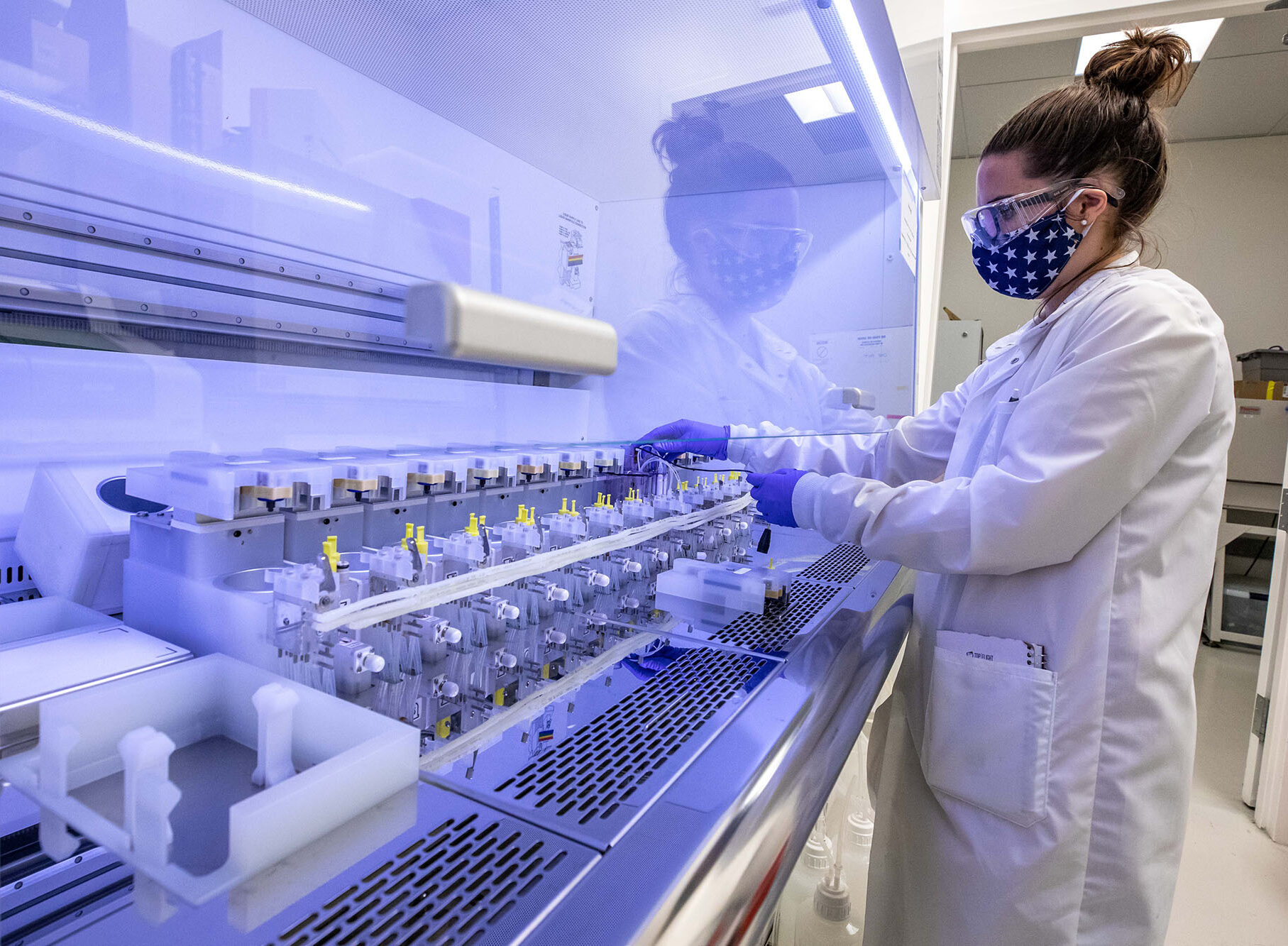 Scientist wearing protective great works on an enclosed bioreactor.