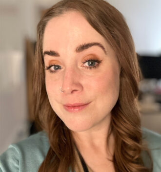 Andrea Taylor, a person with medium-length brown hair wearing a sage-colored top.