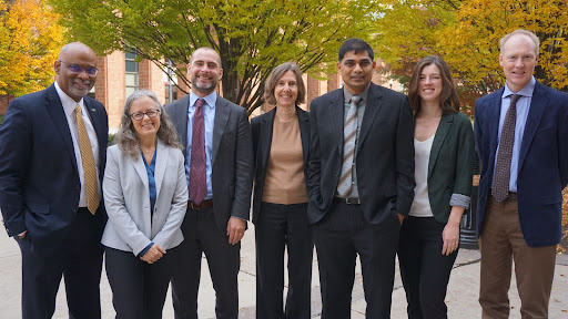 Group of people standing in a single line, facing front.