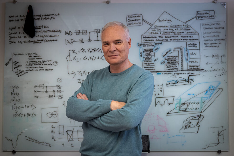 Bert de Jong standing in front of a whiteboard covered in equations.